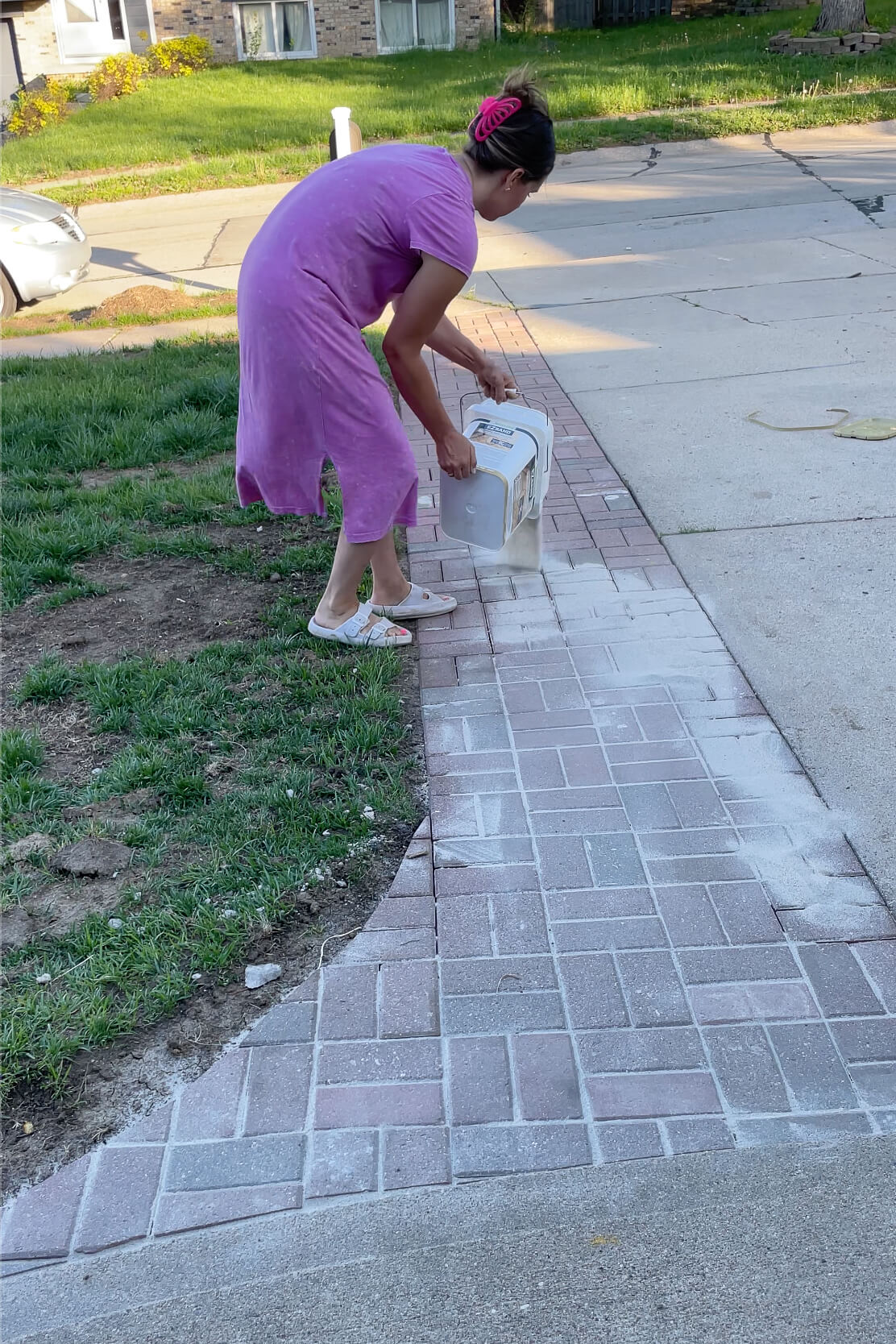 Using polymer sand to finish a paver driveway extension.